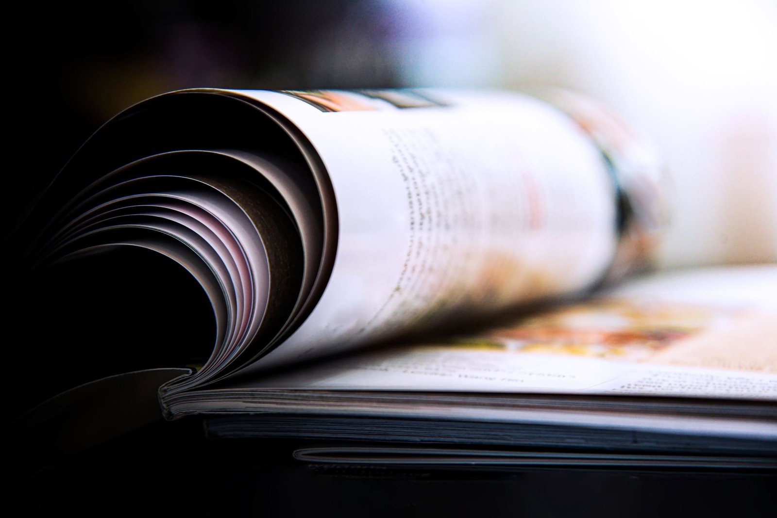 Revista abierta con las páginas curvándose